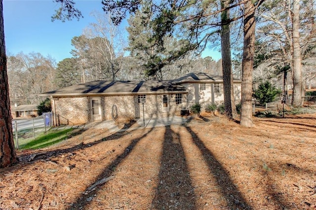 view of front facade featuring brick siding and fence