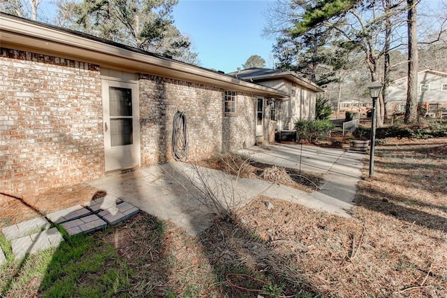 exterior space with a patio area and brick siding