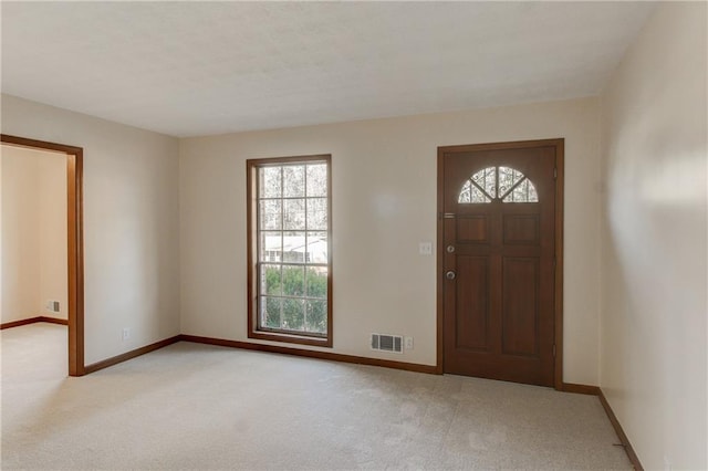 entrance foyer with light carpet, visible vents, and baseboards