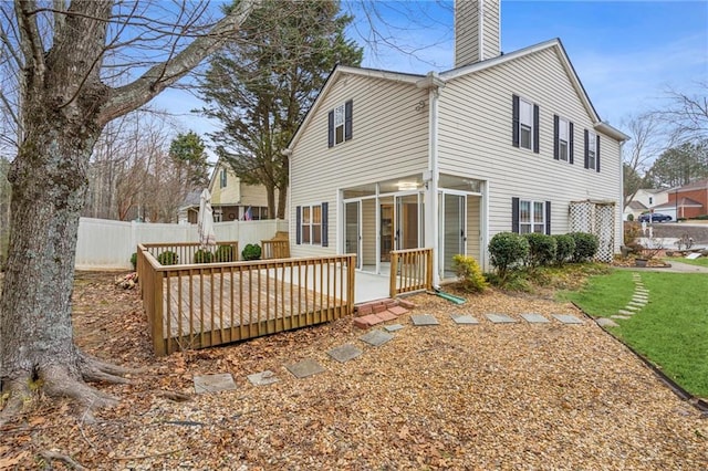 rear view of house with a wooden deck and a yard