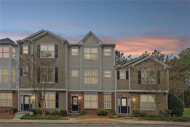 view of property featuring brick siding and stucco siding