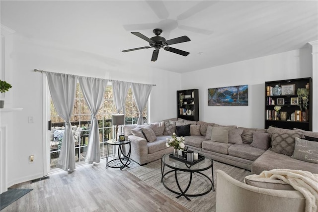living room featuring wood finished floors, ceiling fan, and visible vents