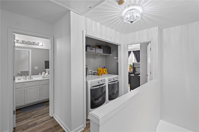 hallway featuring attic access, washer and clothes dryer, a sink, and dark wood finished floors