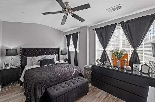 bedroom featuring visible vents, a ceiling fan, wood finished floors, and lofted ceiling