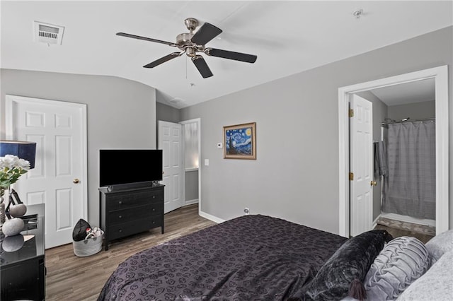 bedroom featuring vaulted ceiling, ensuite bath, visible vents, ceiling fan, and wood finished floors