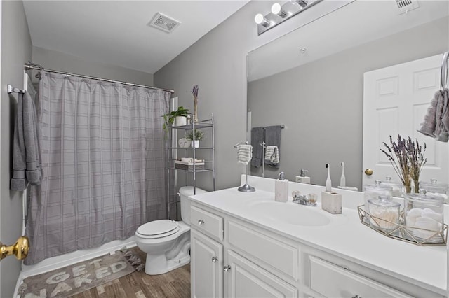full bath with visible vents, toilet, vanity, and wood finished floors