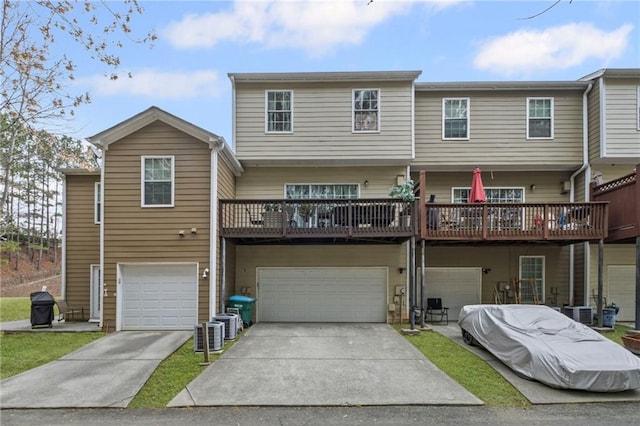 back of property with an attached garage and concrete driveway