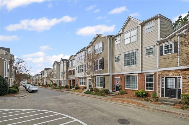 view of street with sidewalks, a residential view, and curbs