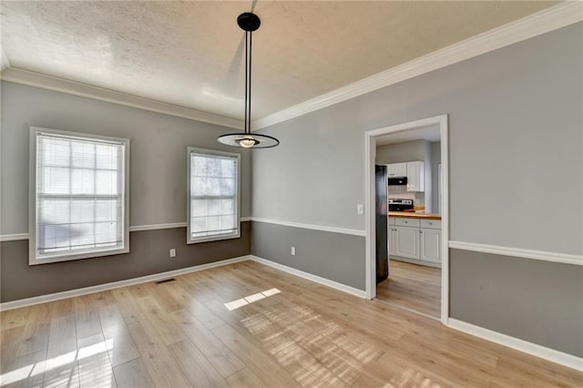 unfurnished dining area with light wood-type flooring, baseboards, and crown molding