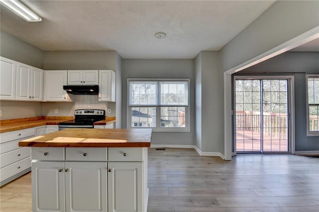 kitchen with stainless steel range with electric stovetop, butcher block counters, light wood-style flooring, and exhaust hood