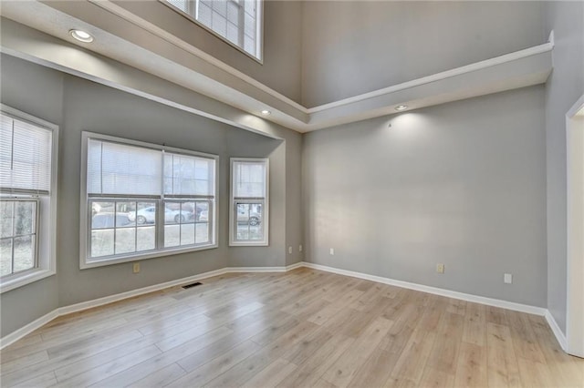 unfurnished room with baseboards, a wealth of natural light, and wood finished floors