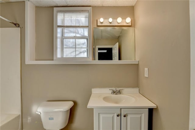 bathroom featuring a paneled ceiling, vanity, and toilet