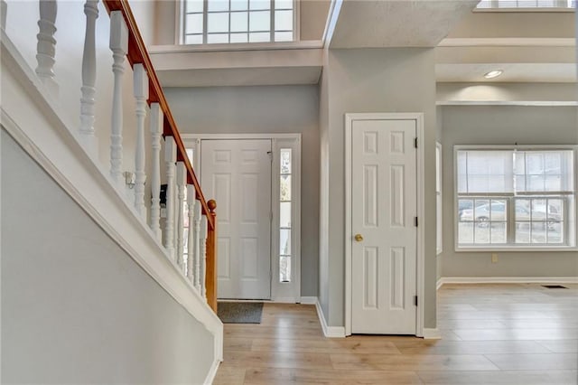 entrance foyer featuring stairway, baseboards, and wood finished floors