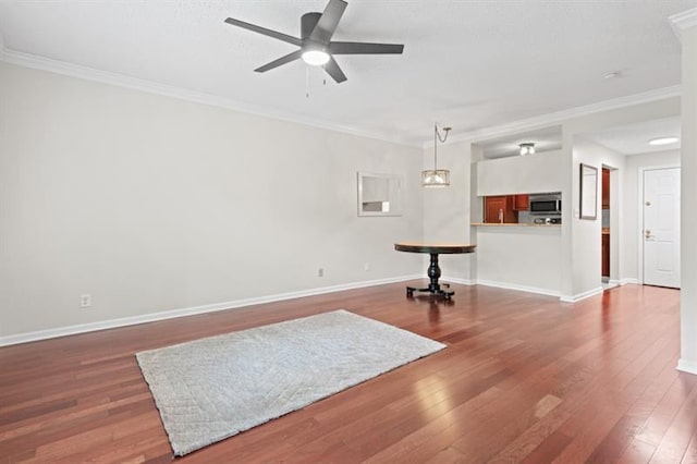 unfurnished living room featuring hardwood / wood-style flooring, ceiling fan, and crown molding