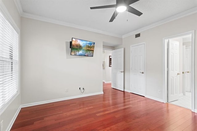 unfurnished bedroom featuring ceiling fan, ornamental molding, and hardwood / wood-style flooring