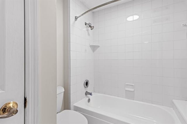 bathroom featuring tiled shower / bath and toilet