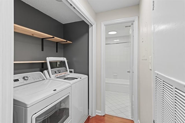 laundry area featuring washing machine and dryer and wood-type flooring