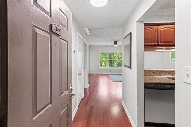 hall featuring a textured ceiling and dark hardwood / wood-style floors