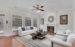 living room with hardwood / wood-style flooring, crown molding, and ceiling fan