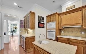 kitchen featuring crown molding, sink, white appliances, and decorative backsplash