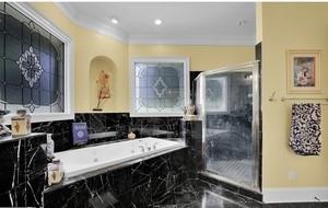 bathroom with ornamental molding and tiled bath