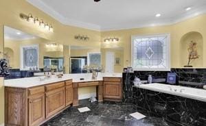 bathroom with tasteful backsplash, crown molding, a tub, and vanity