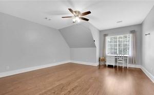 bonus room with lofted ceiling, dark hardwood / wood-style floors, and ceiling fan