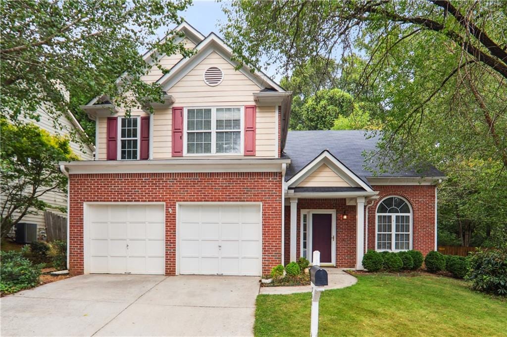 view of property with a garage and a front lawn