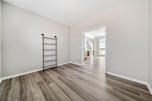 unfurnished room with visible vents, baseboards, and wood finished floors