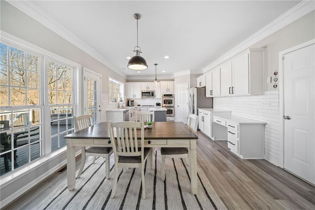 dining area featuring crown molding, recessed lighting, and wood finished floors