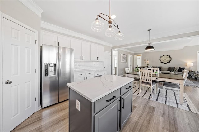 kitchen featuring gray cabinets, open floor plan, a center island, white cabinetry, and stainless steel fridge