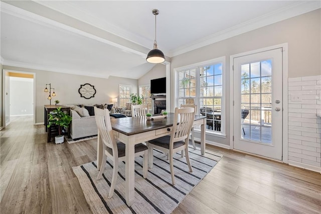 dining space featuring vaulted ceiling, crown molding, and wood finished floors