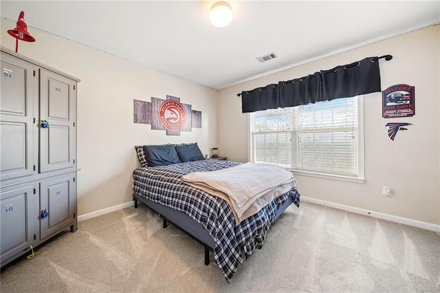 bedroom with light carpet, visible vents, and baseboards