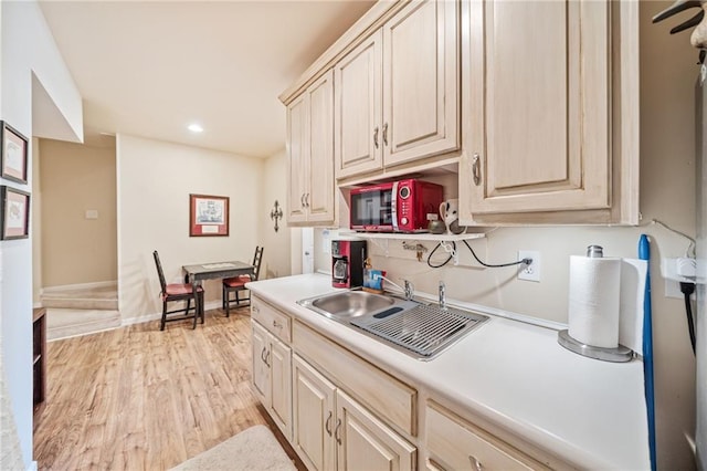 kitchen featuring a sink, recessed lighting, light countertops, and light wood finished floors