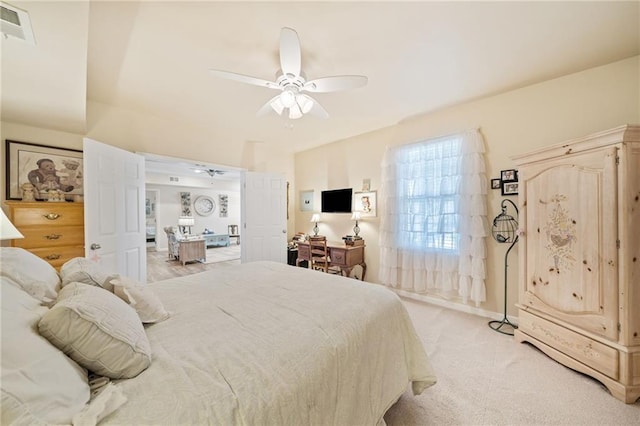 bedroom featuring light colored carpet, visible vents, and ceiling fan