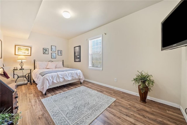 bedroom with wood finished floors and baseboards