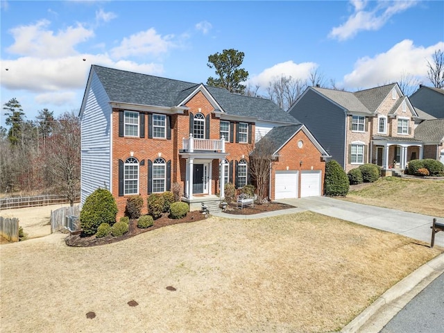 view of front facade with fence, concrete driveway, a front lawn, a garage, and brick siding