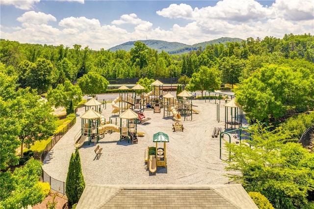 view of home's community featuring a mountain view, a forest view, and playground community