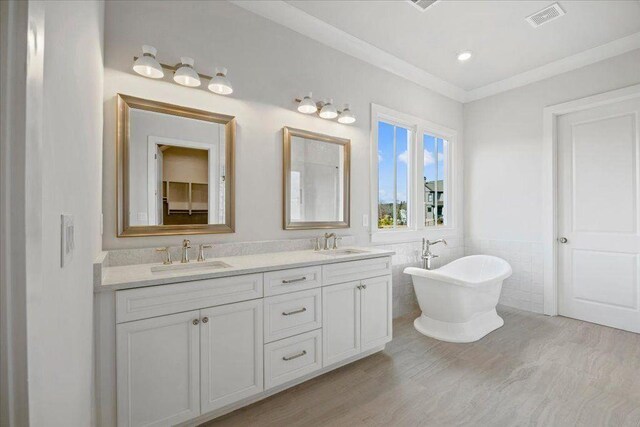 2035 Village Walk, Milton, GA 30004 - bathroom featuring double vanity, wood finished floors, a freestanding bath, tile walls, and wainscoting