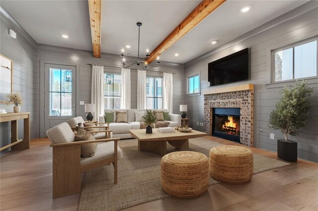 2035 Village Walk, Milton, GA 30004 - living area with wood finished floors, plenty of natural light, a brick fireplace, and beamed ceiling