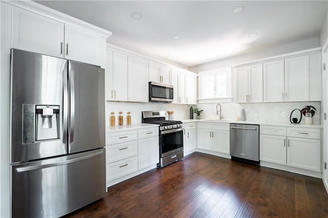 943 Rose Cir SW, Atlanta, GA 30310 - kitchen featuring stainless steel appliances, light countertops, white cabinetry, decorative backsplash, and dark wood finished floors