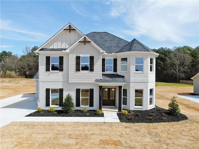 view of front of house with french doors, brick siding, board and batten siding, and a shingled roof