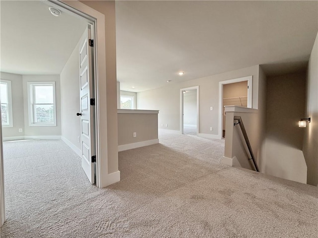 spare room with carpet, a wealth of natural light, and baseboards