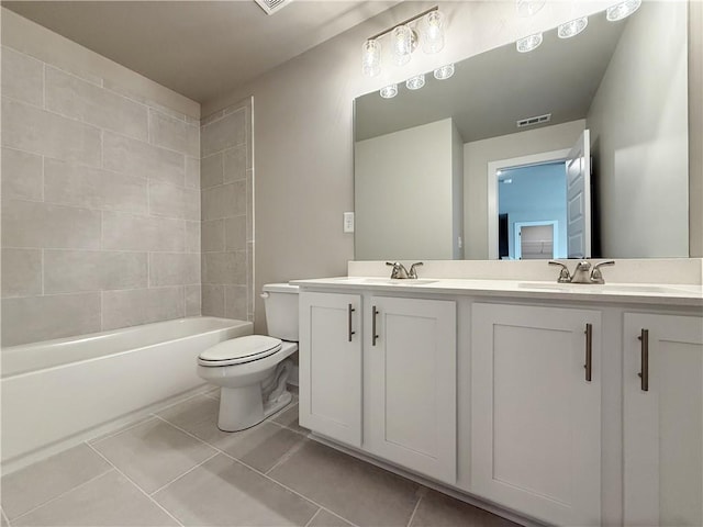 bathroom with double vanity, visible vents, toilet, tile patterned floors, and a sink