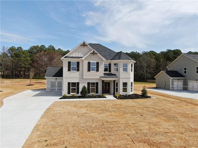 view of front of home featuring a front lawn, board and batten siding, and concrete driveway