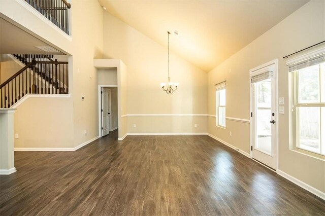 610 Sunflower Dr, Canton, GA 30114 - unfurnished living room with a chandelier, dark wood-type flooring, high vaulted ceiling, healthy amount of natural light, and stairway