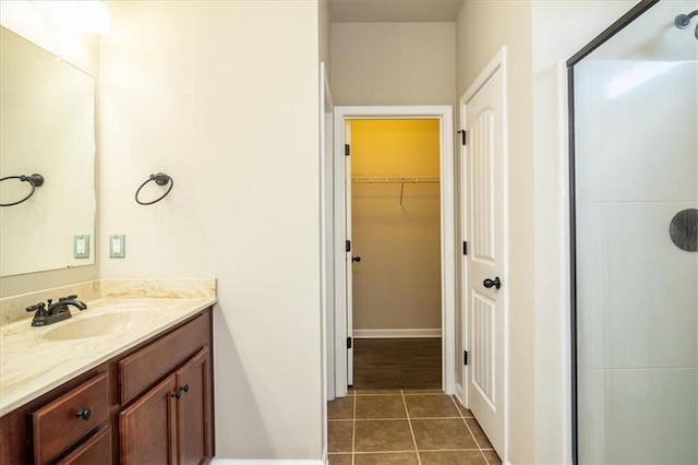 610 Sunflower Dr, Canton, GA 30114 - full bathroom with vanity, a shower stall, tile patterned floors, a walk in closet, and baseboards