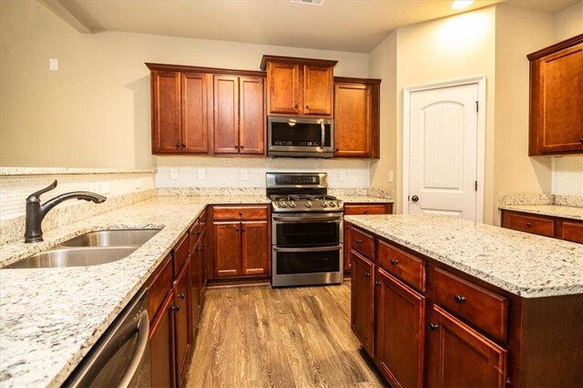 610 Sunflower Dr, Canton, GA 30114 - kitchen featuring appliances with stainless steel finishes, a sink, dark wood finished floors, light stone countertops, and tasteful backsplash