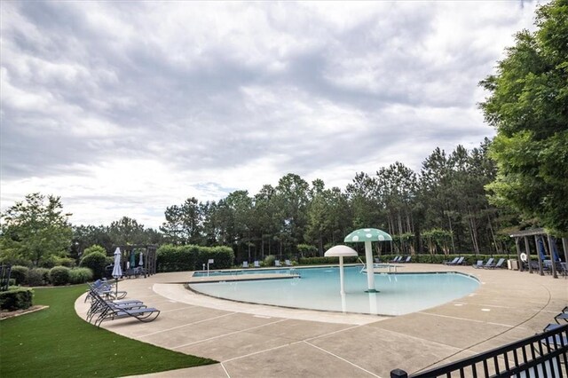 610 Sunflower Dr, Canton, GA 30114 - community pool featuring a patio area, view of wooded area, and a yard