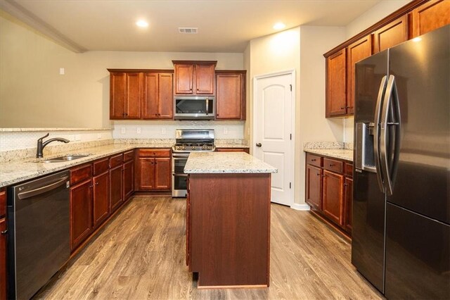 610 Sunflower Dr, Canton, GA 30114 - kitchen with appliances with stainless steel finishes, a sink, wood finished floors, a center island, and light stone counters